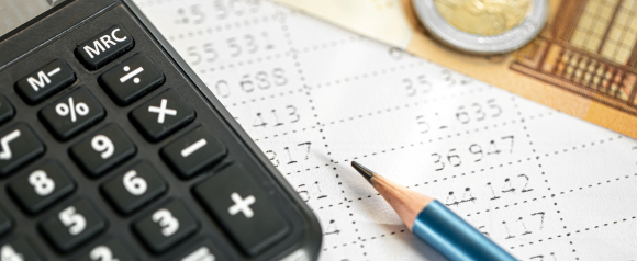 Close-up of a calculator, pencil, and printed financial figures on a receipt with euro currency in the background, representing accounting or financial review, relevant to services like those offered by Tax Network USA.
