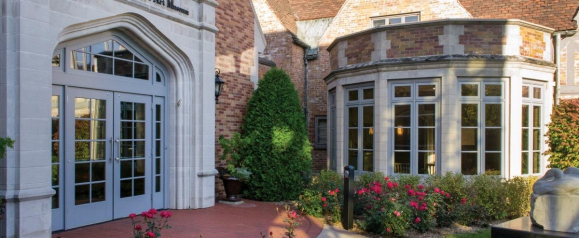 A traditional brick building with elegant Kolbe windows and doors, including a grand arched entrance framed by divided lites and a curved bay window that brings in natural light. The windows complement the historic architecture while offering modern energy efficiency.