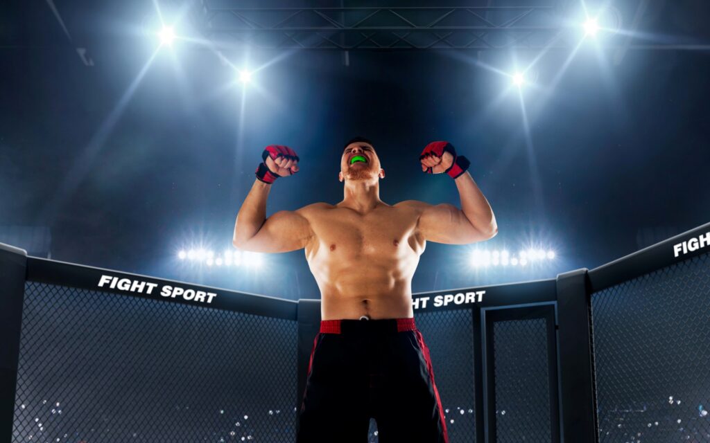 A victorious MMA fighter flexing his muscles in the cage under bright lights, representing the peak physical condition supported by the best supplements for MMA training.