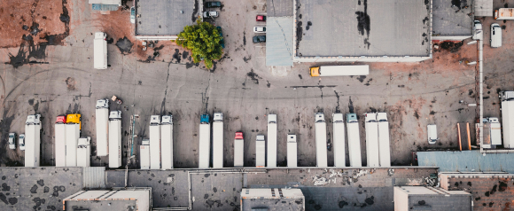 Aerial view of trucks parked in a commercial lot, illustrating Motive’s fleet and vehicle tracking capabilities.