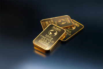 Gold bars stacked on a dark surface, labeled with weight and purity (fine gold 999.9), representing physical gold assets commonly used in Gold IRA investments.