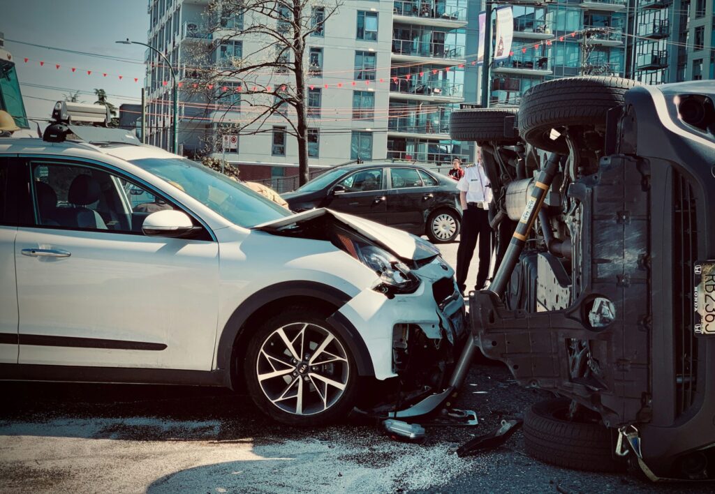 Scene of a severe intersection collision involving a flipped vehicle, illustrating complex liability cases often handled by an auto accident lawyer