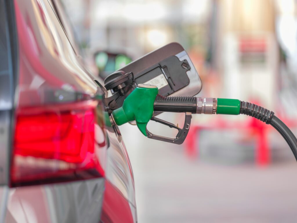 A fuel nozzle pumping gasoline into a vehicle's tank, representing personal fuel expenses that often trigger an IRS Fuel Tax Credit Audit if claimed improperly.