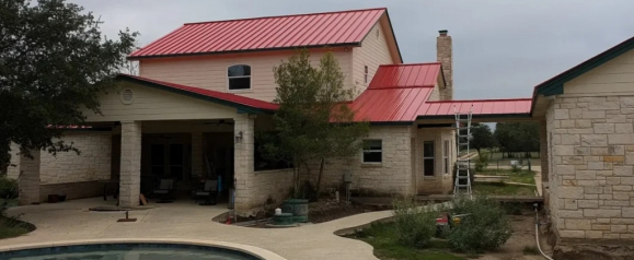 Residential home with light stone exterior and a bold red metal roof, featuring a covered patio, a swimming pool in the foreground, and a ladder set up for roof access. The image likely shows ongoing or recently completed work by O C Roofing Services.