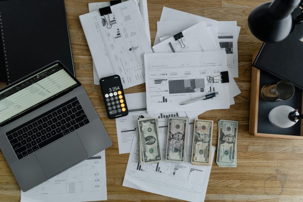 Comparison of payroll documents and cash stacks on a desk representing Gusto vs Paychex cost analysis