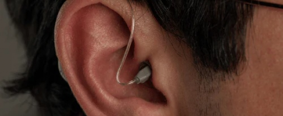 Close up of a person’s ear wearing a discreet in ear hearing aid that fits snugly inside the ear canal. The small device blends naturally with the skin tone, highlighting comfort and subtle design. The image showcases Zepp Clarity hearing aids as a modern and nearly invisible solution for clearer everyday hearing.