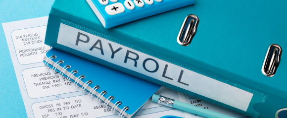 Office payroll documents with a blue binder labeled 