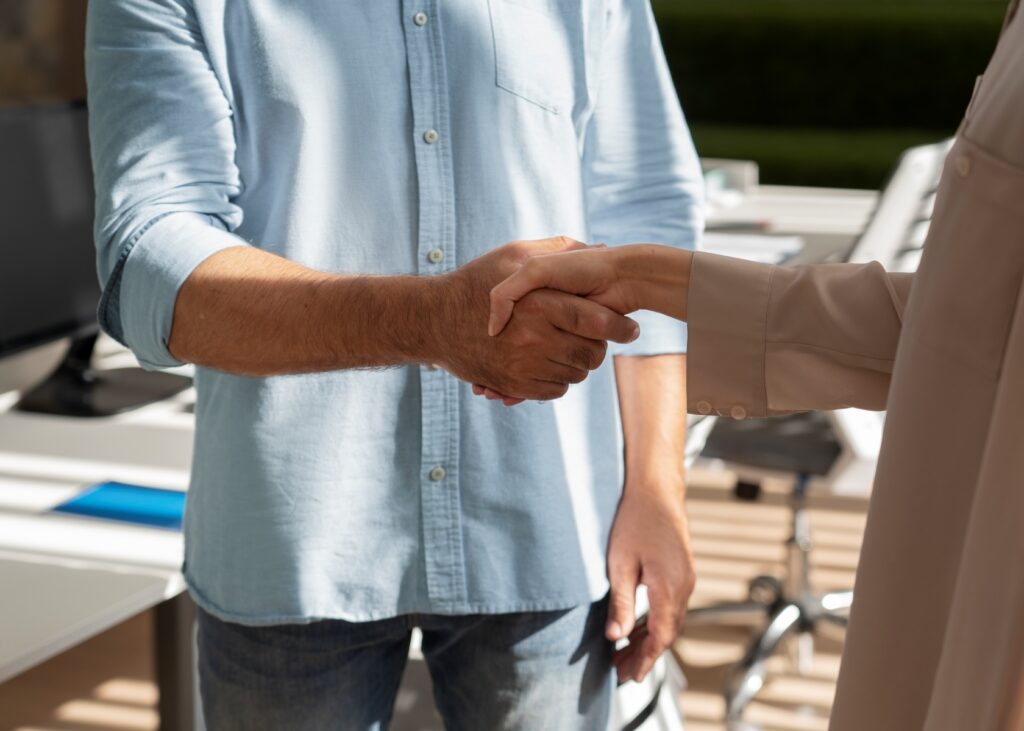 Taxpayer shaking hands with a tax relief professional after reaching an IRS Offer in Compromise agreement