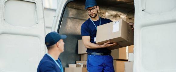 Delivery workers unloading packages from a van, representing logistics operations and shipment tracking with Alvys transportation management software.