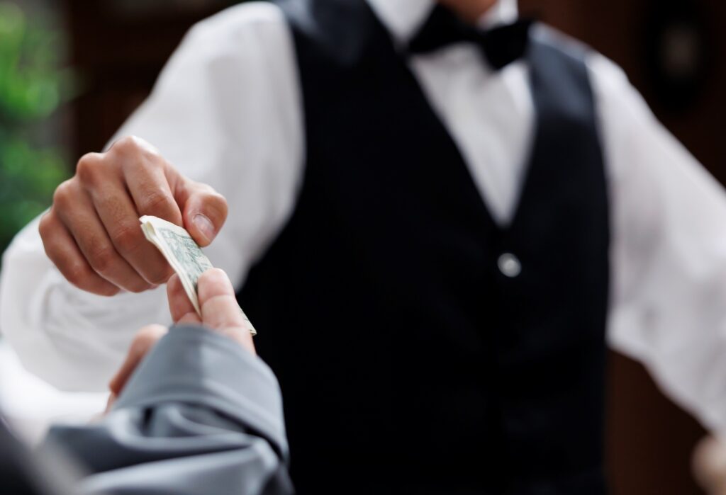 Waiter receiving a cash tip from a customer at a restaurant
