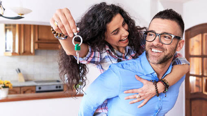 Smiling couple meeting with a mortgage loan officer to sign paperwork at a desk