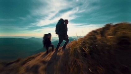 Two backpackers hiking up a mountain ridge against a dramatic cloudy sky.