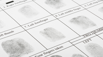 Close-up of a fingerprint card with labeled prints used for a background check.