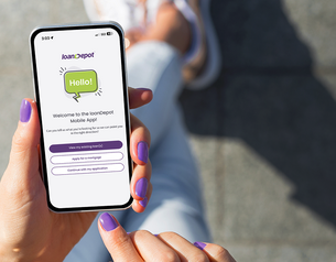 Hand holding a smartphone showing the loanDepot mobile app welcome screen with mortgage and loan options