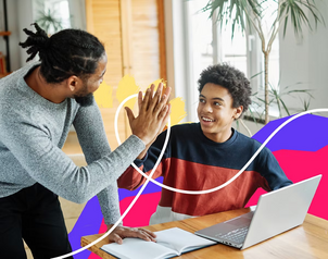 Father and teenage son high-fiving over a laptop and notebook while studying at home, with colorful graphic accents