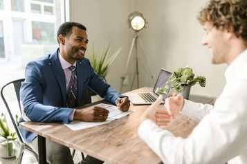 Thimble insurance agent in a blue suit discussing a small business coverage policy with a client across a deskThimble insurance agent in a blue suit discussing a small business coverage policy with a client across a desk